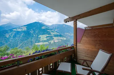 a bedroom with a bed and a desk and a television at Der Verdinser Hof in Schenna
