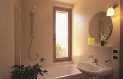 a bathroom with a tub and a sink and a window at Al Cargà in San Vigilio Di Marebbe