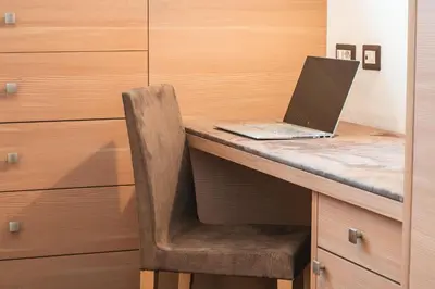 a laptop computer sitting on top of a wooden desk at Arjentel Lodge in Selva di Val Gardena
