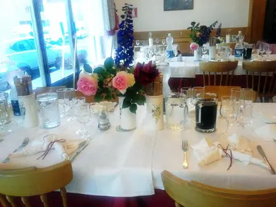 a table with a white table cloth and flowers on it at Albergo Posta in Colle Santa Lucia