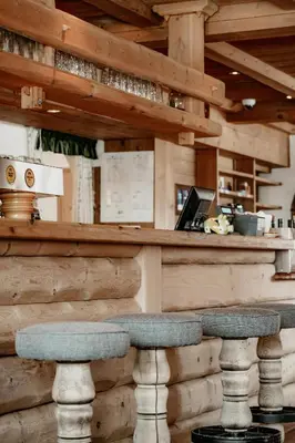 a wooden bar with two seats at a counter at Ütia De Börz in San Martino in Badia