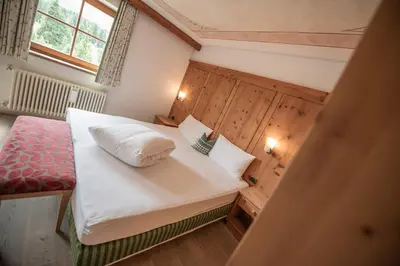 a bedroom with a bed with white sheets and pillows at Ütia De Börz in San Martino in Badia