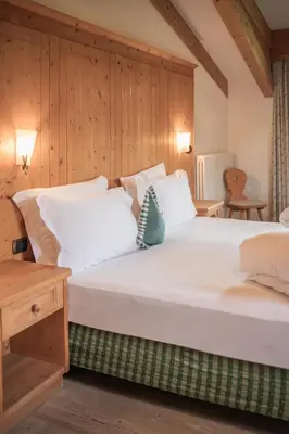 a bedroom with two beds and a wooden wall at Ütia De Börz in San Martino in Badia