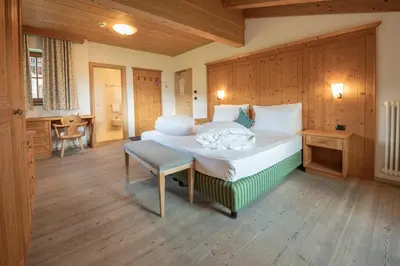 a bedroom with a bed and a table and a chair at Ütia De Börz in San Martino in Badia