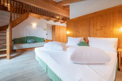 two white beds in a room with a bedroom at Ütia De Börz in San Martino in Badia