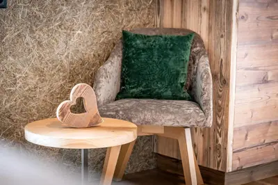 a chair and a table with a wooden heart on it at Planatschhof in Villnoss