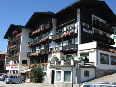a large white building with balconies and flowers on it at GH Hotel Monzoni in Pozza di Fassa