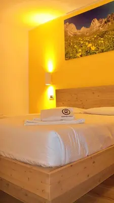 a hotel room with a bed with a towel on it at GH Hotel Monzoni in Pozza di Fassa