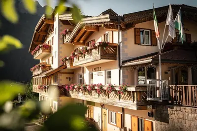 a building with flower boxes and balconies on it at Al Piccolo Hotel in Vigo di Fassa