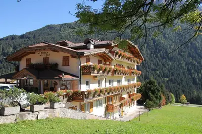 a building with flowers on the balconies of it at Al Piccolo Hotel in Vigo di Fassa