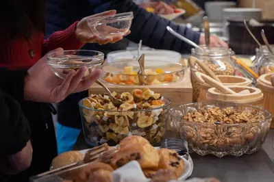 a group of people standing around a table with food at Al Piccolo Hotel in Vigo di Fassa