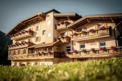 a large building with balconies and flowers on it at Al Piccolo Hotel in Vigo di Fassa