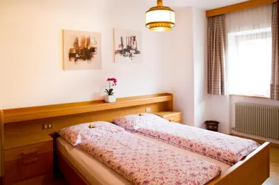 a bedroom with two beds and a window at Apartments Ruac in La Valle