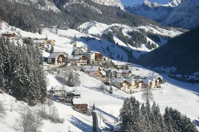 a small town on a snowy mountain with houses at Apartments Ruac in La Valle