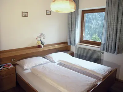 a bedroom with two beds and a window at Apartments Ruac in La Valle