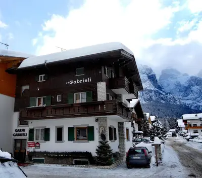 a building with a car parked in front of it at Garni Gabrieli in Corvara in Badia