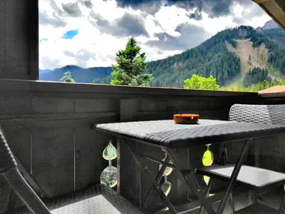 a table and chairs in front of a large window at Garni Gabrieli in Corvara in Badia