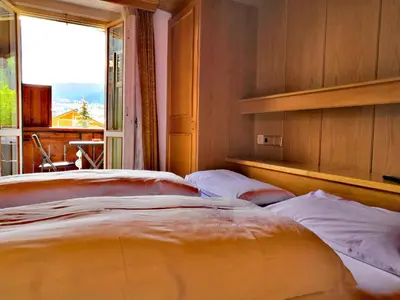 two beds in a room with a large window at Garni Gabrieli in Corvara in Badia