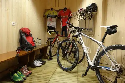 a bike parked in a room with helmets and shoes at Villa Perla in Selva di Val Gardena