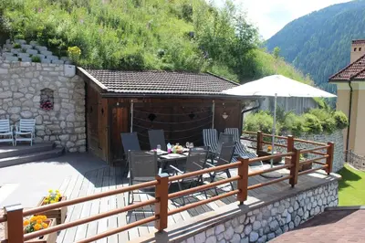 a large wooden deck with a table and chairs on it at Villa Perla in Selva di Val Gardena