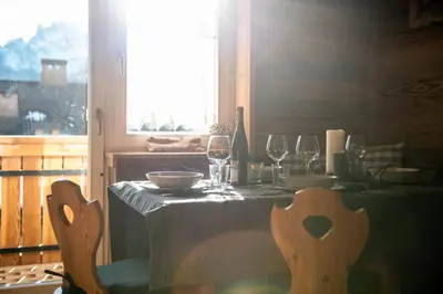 a table with wine glasses and a table cloth at Laurino Apartment in Campitello di Fassa