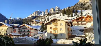 a view of a snowy mountain from a window at Laurino Apartment in Campitello di Fassa