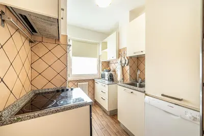 a small kitchen with white appliances and a window at Laurino Apartment in Campitello di Fassa