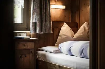 a bed with white sheets and pillows in a room at Pension Pcei in Picciai