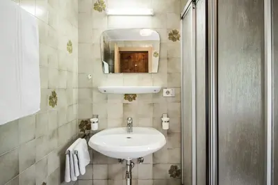 a bathroom with a sink and a mirror at Pension Pcei in Picciai