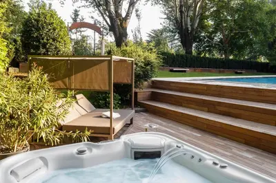 a bath tub in a yard with a pool at Windsor Merano Hotel & Suites in Merano