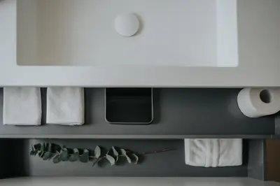 a bathroom with towels and a shelf at Windsor Merano Hotel & Suites in Merano