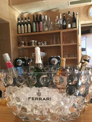 a bunch of wine glasses and bottles on a counter at Hotel Meisules in Selva di Val Gardena