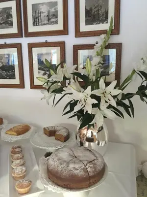 a table with a cake and a vase of flowers at Hotel Meisules in Selva di Val Gardena
