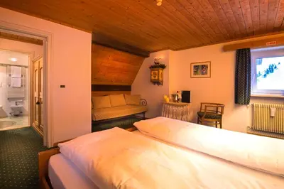 a room with two bunk beds and a window at Hotel Cir in Selva di Val Gardena