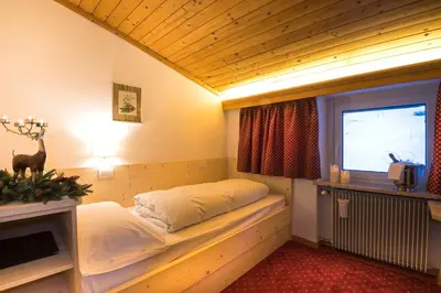 a room with a bed in the corner of a room at Hotel Cir in Selva di Val Gardena