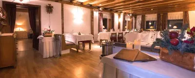 a dining room with white tables and white tablecloths at Hotel Cir in Selva di Val Gardena