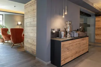 a lobby with a counter with pots and pans on it at Hotel Alpi in Campitello di Fassa