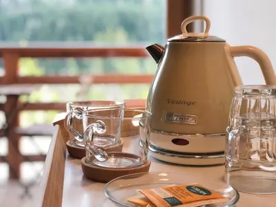 a tea kettle and glasses on a table at Agriturismo Soreie - Farmstay in Vigo di Fassa