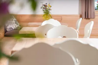 a vase with flowers in it sitting on a table at Agriturismo Soreie - Farmstay in Vigo di Fassa