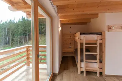 a house with wooden balconies and a mountain at Agriturismo Soreie - Farmstay in Vigo di Fassa