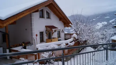 a house covered in snow on a balcony at B&B L'Arca di Noè in Laion