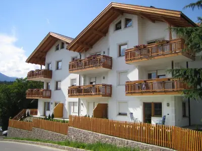 a white building with wooden balconies and a fence at B&B L'Arca di Noè in Laion