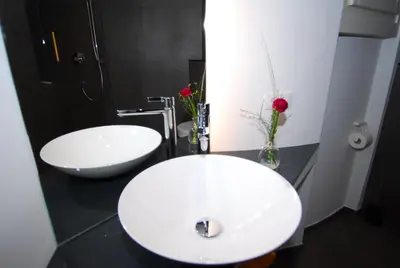 a bathroom with two white sinks on a black counter at Torilan in Terlano