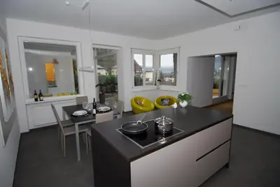 a kitchen with a black counter and yellow chairs at Torilan in Terlano