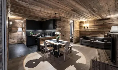 a dining room with a table and a couch at Chalet Cogolara in Colfosco