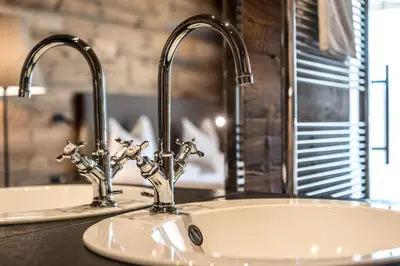 a bathroom sink with two faucets on a counter at Chalet Cogolara in Colfosco