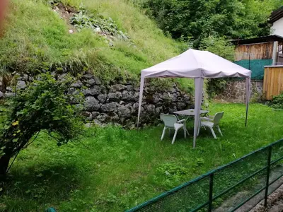 a table and chairs under an umbrella in a yard at Il Giornalgaio in Canazei
