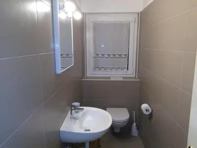 a bathroom with a sink and a toilet and a window at Il Giornalgaio in Canazei