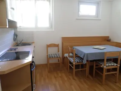 a kitchen with a table and chairs and a sink at Il Giornalgaio in Canazei