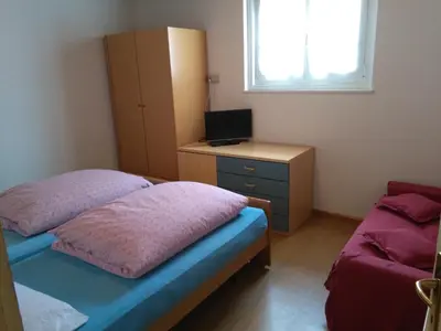 a bedroom with a bed and a desk with a television at Il Giornalgaio in Canazei
